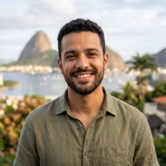 Lucas Almeida sorridente com cenário de viagem ao fundo